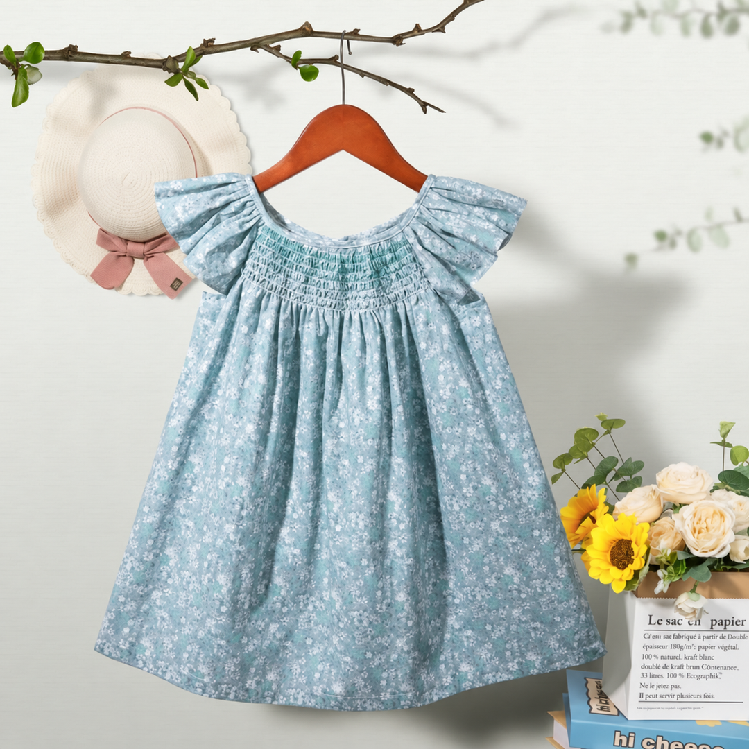 Blue floral dress on a wooden hanger, with flutter sleeves and a smocked bodice.