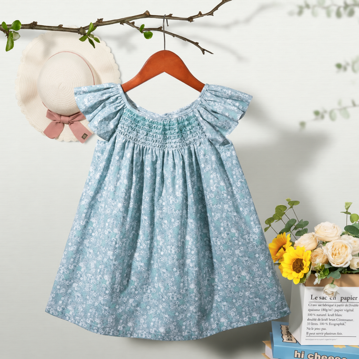 Blue floral dress on a wooden hanger, with flutter sleeves and a smocked bodice.