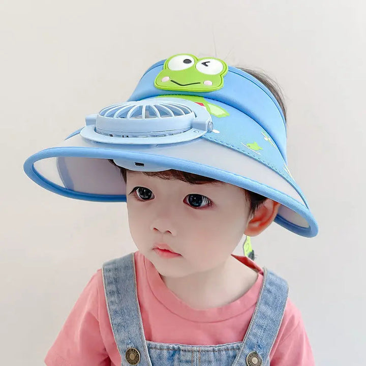Child wearing a blue fan hat with a frog decoration and wide brim