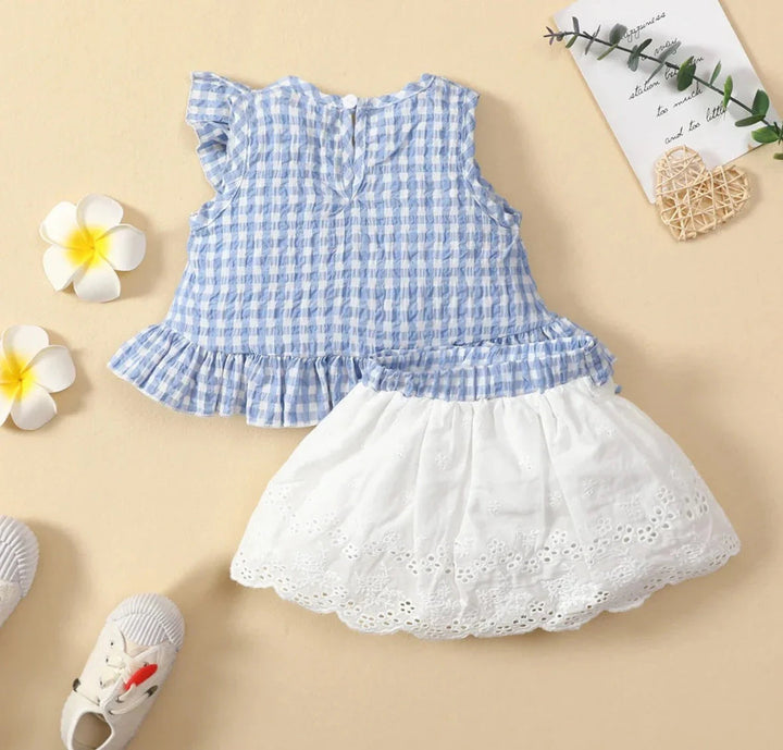 Back view of the blue gingham top shown with a white scalloped eyelet skirt