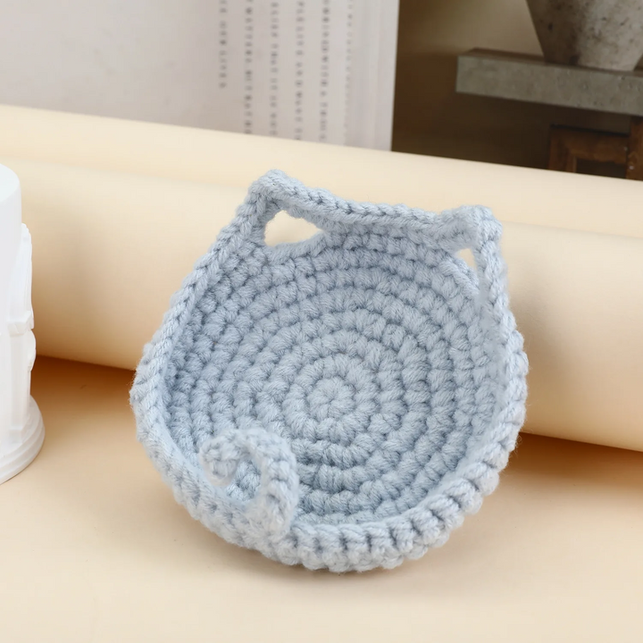 Pale blue-gray cat coaster with pointed ears, a raised rim, and a curled tail