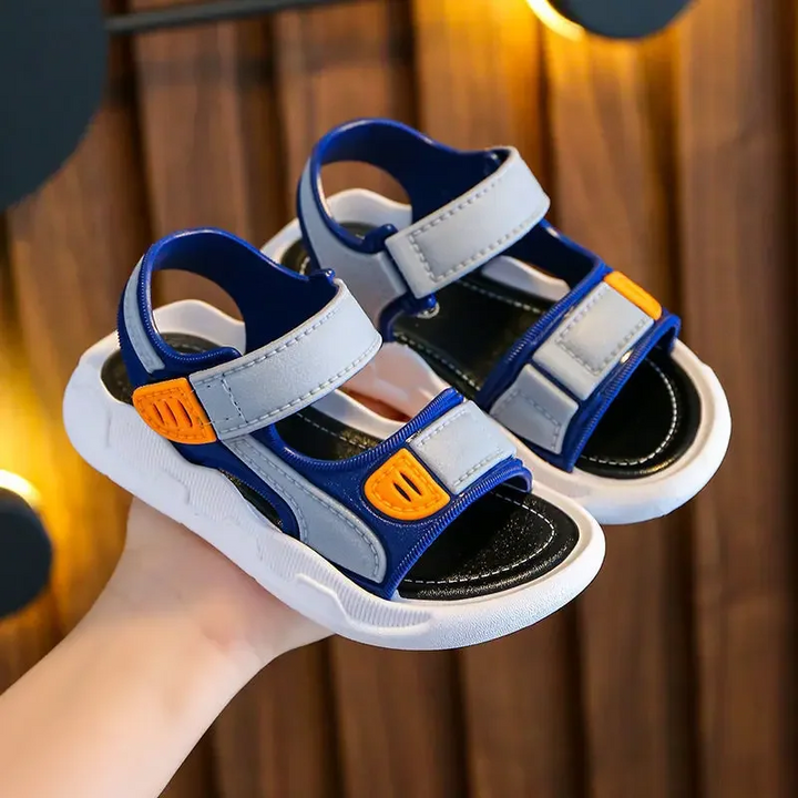 Blue and gray sandals with orange strap details, black footbeds, and white soles