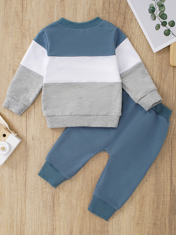 Blue, white and gray sweatshirt paired with blue joggers and white side stripes