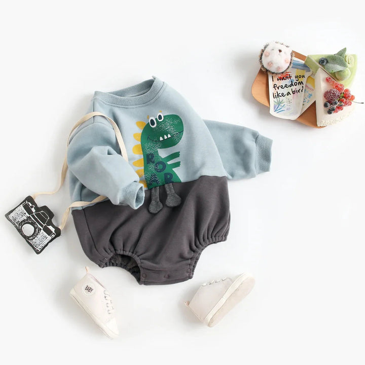 Blue baby romper with a green dinosaur, long sleeves, and a dark gray lower half