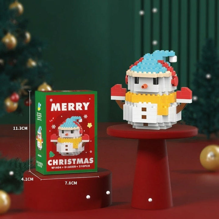 Mini snowman block figure wearing a blue hat and yellow scarf beside its box