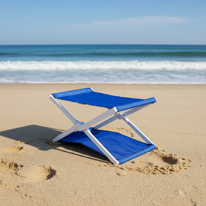 Blue fabric headrest opened on beach sand with ocean waves behind it