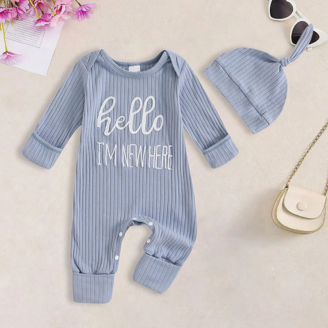 Blue ribbed baby jumpsuit with white hello lettering, cuffed ankles and a matching beanie