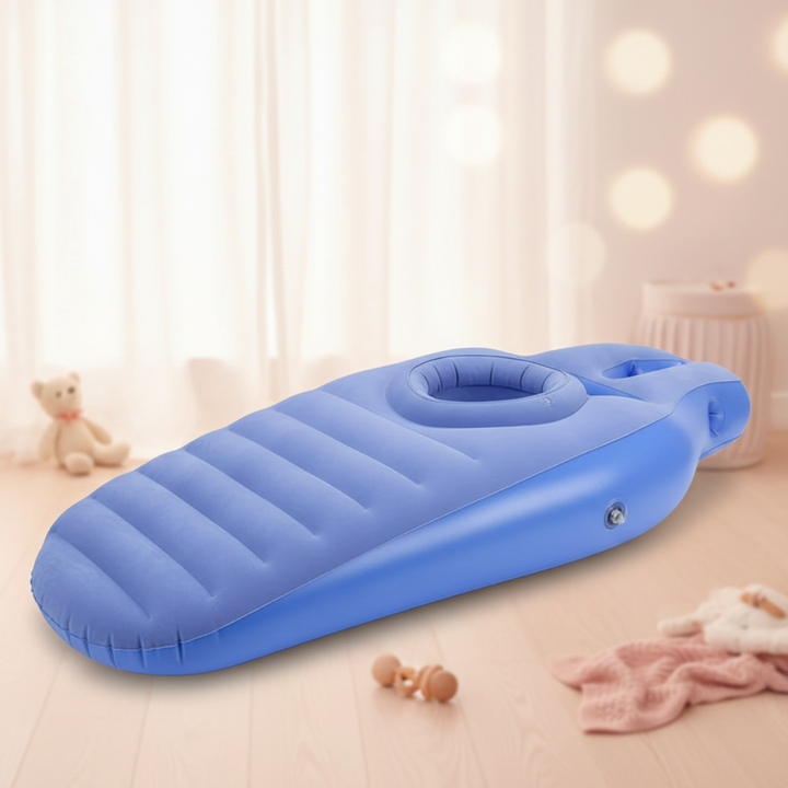 Blue inflatable pregnancy pillow with a raised circular belly opening on a wooden floor