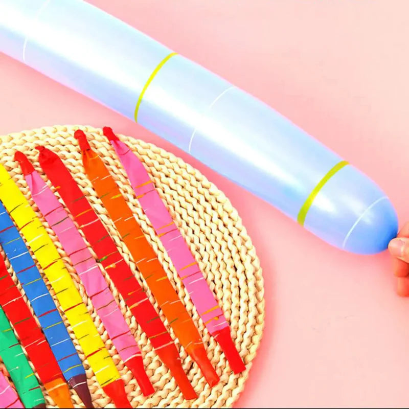 Inflated light blue rocket balloon beside rows of uninflated balloons on a woven mat
