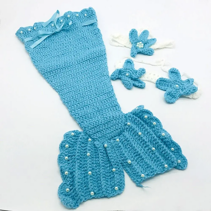 Blue knitted mermaid tail with a ribbon bow, wide fin, and coordinating starfish accessories