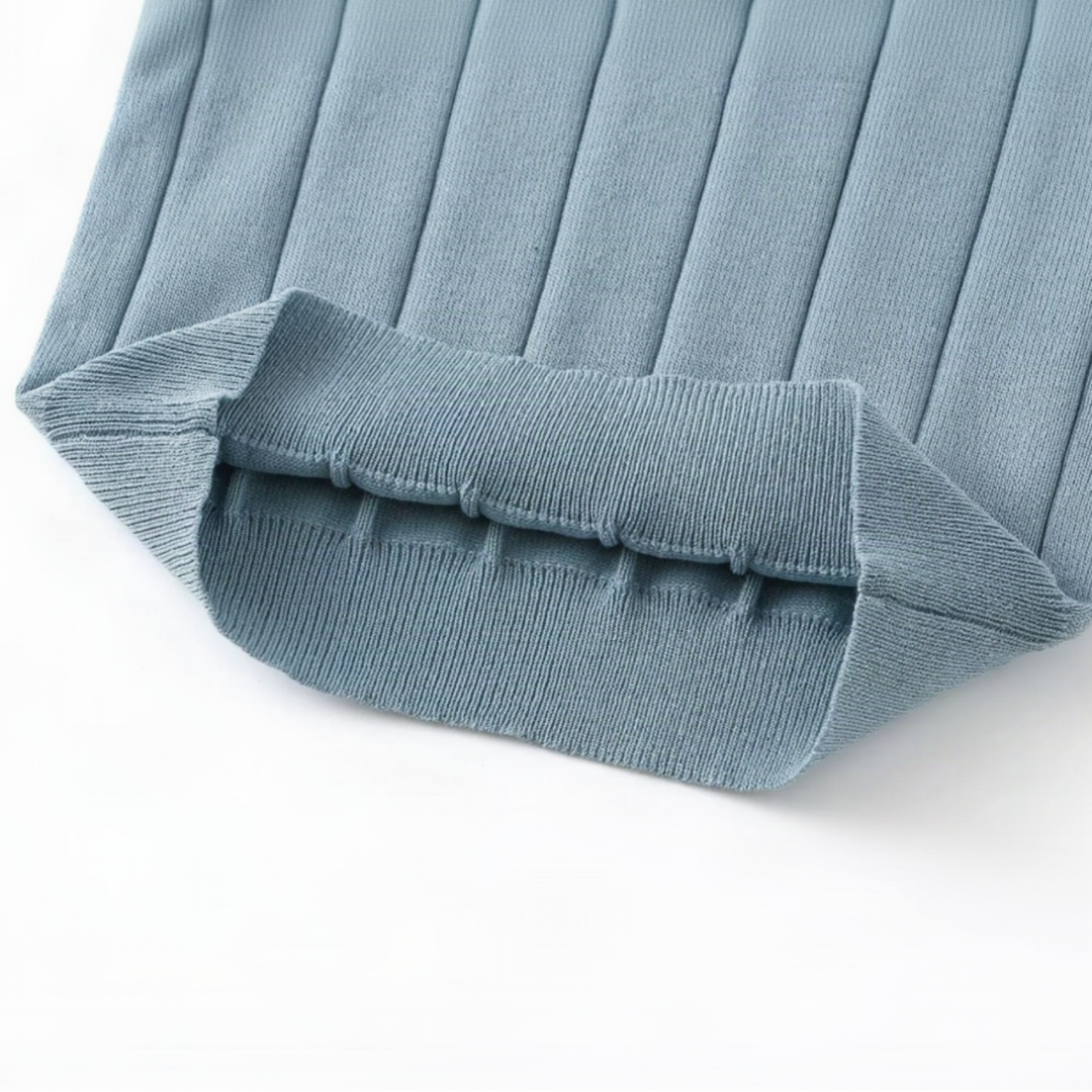 Folded hem of the blue knit polo shirt showing the inside of the ribbed edge