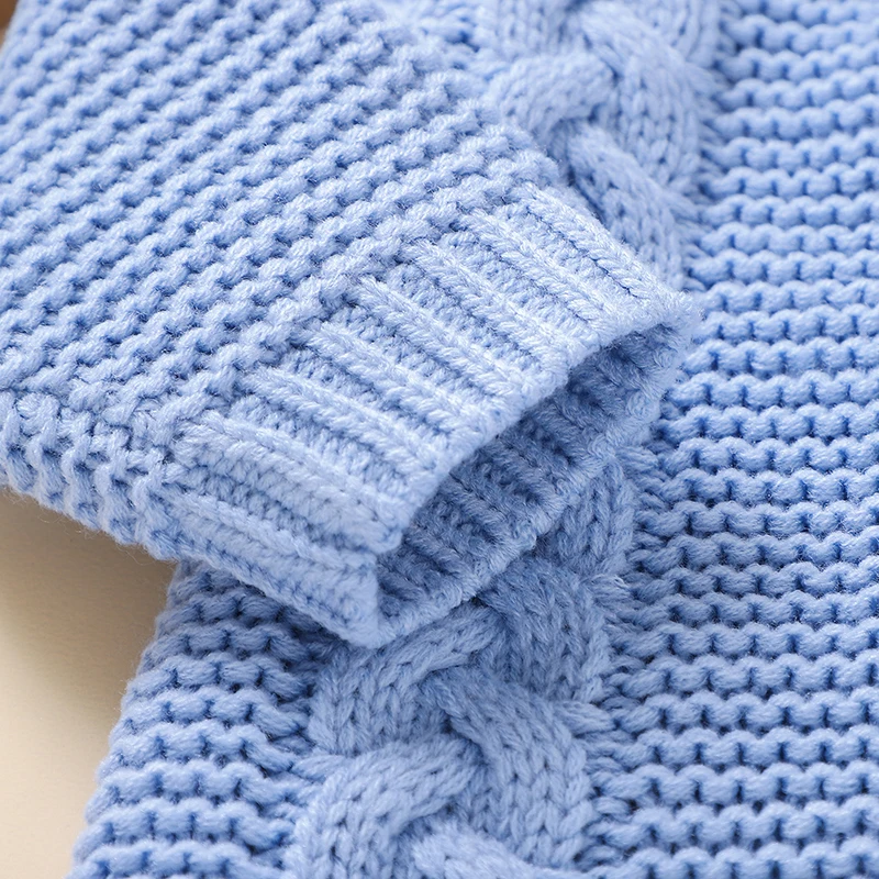 Blue knitted sleeve showing a ribbed cuff beside raised cable detailing