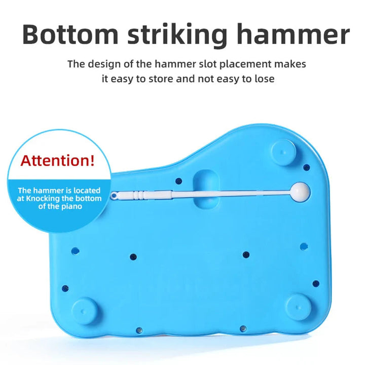 Underside of the blue music toy with a white mallet stored in its built-in slot
