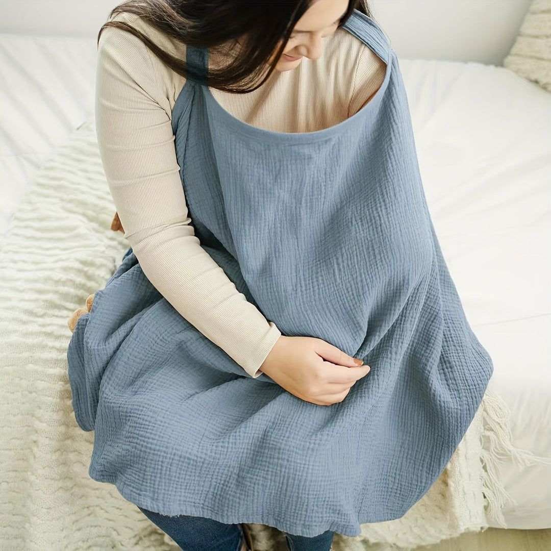 Seated mother wearing a blue cotton nursing scarf