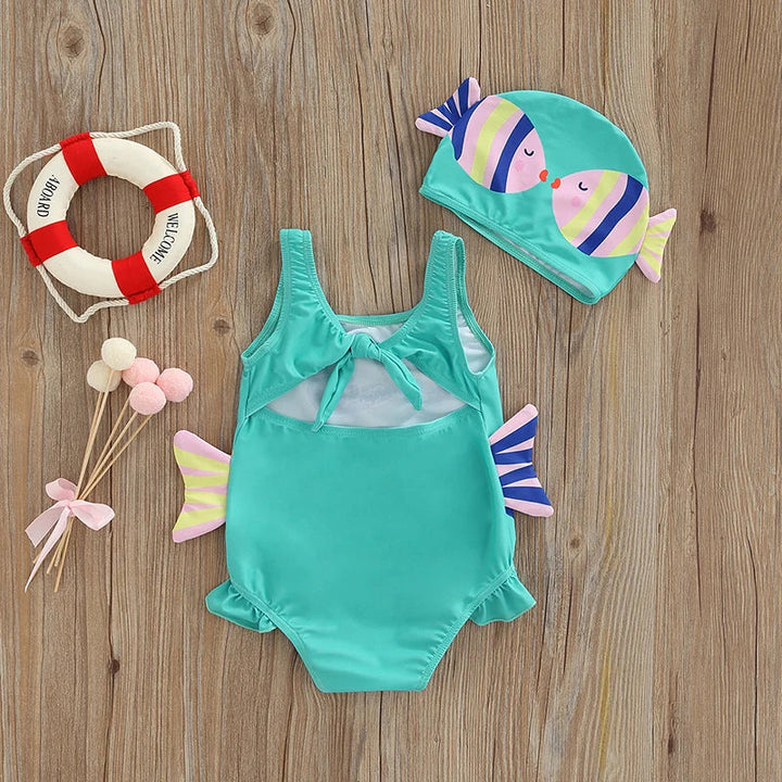 Back view of the blue swimsuit with shoulder straps, ruffled leg openings, and a matching cap