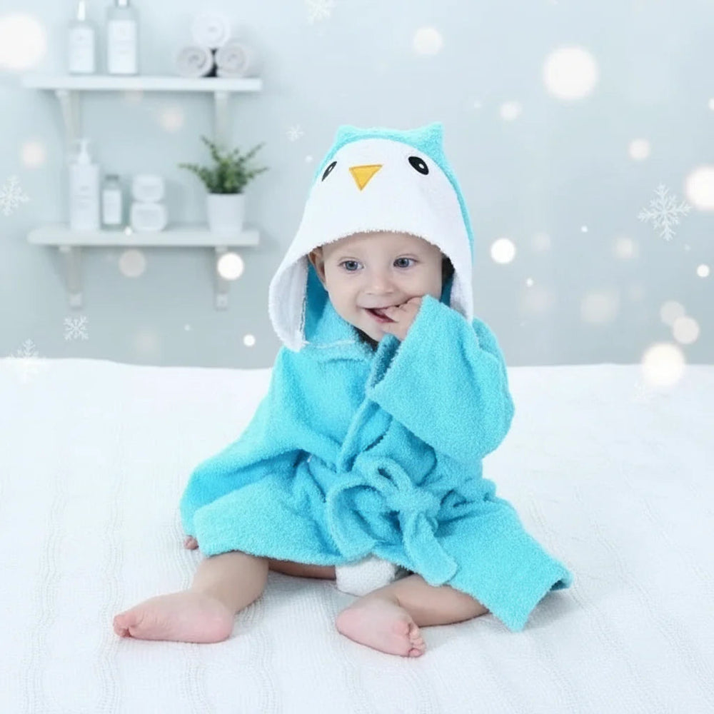 Baby wearing a blue owl bathrobe with a white face and yellow beak on the hood