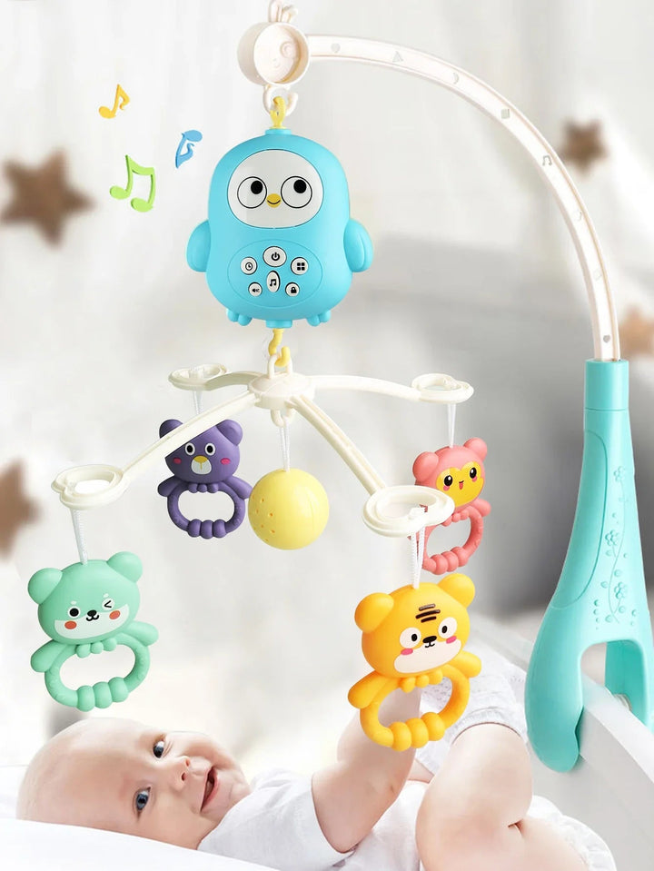 Baby reaching toward colorful hanging toys on a blue owl musical crib mobile.