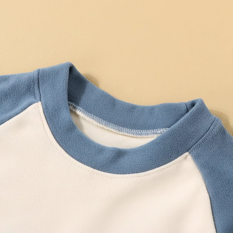 Close-up of the blue crewneck collar and cream-colored front of the pajama top.
