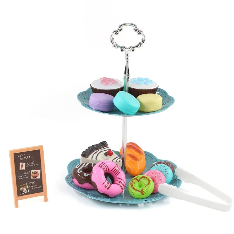 Blue two-tier pastry stand with pretend cakes, donuts and macarons, plus tongs and a menu board