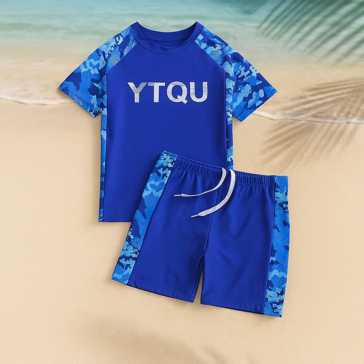 Blue swim shirt and drawstring shorts with patterned sleeves and side panels on sand