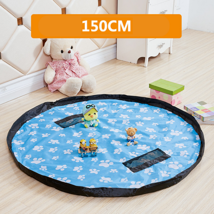 Blue round play mat and storage bag with white paw prints and black mesh pockets.