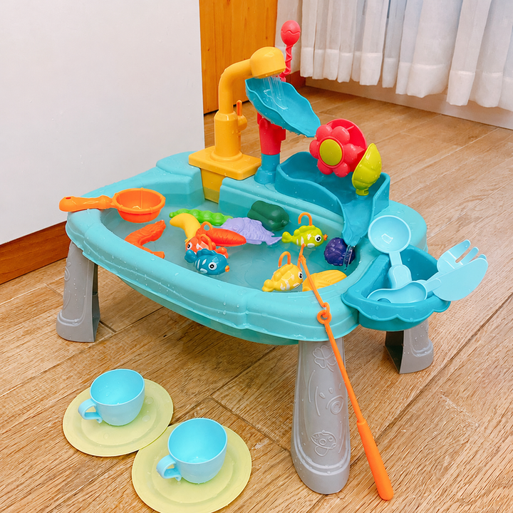 Blue play sink on legs with a faucet, flower water wheel, fishing rod, fish, cups and plates