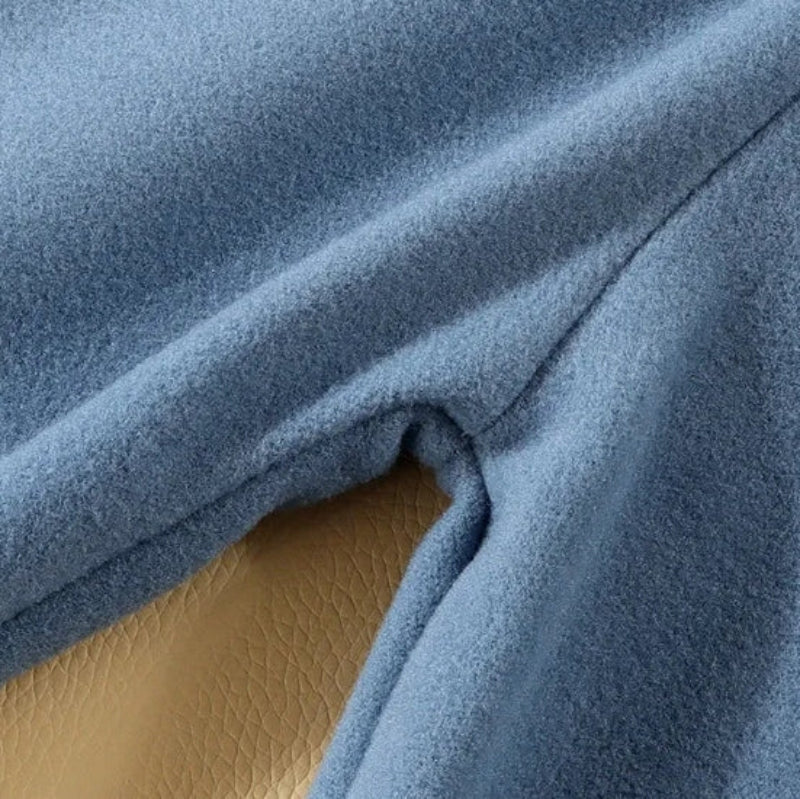 Close-up of blue polar fleece fabric and a stitched seam.