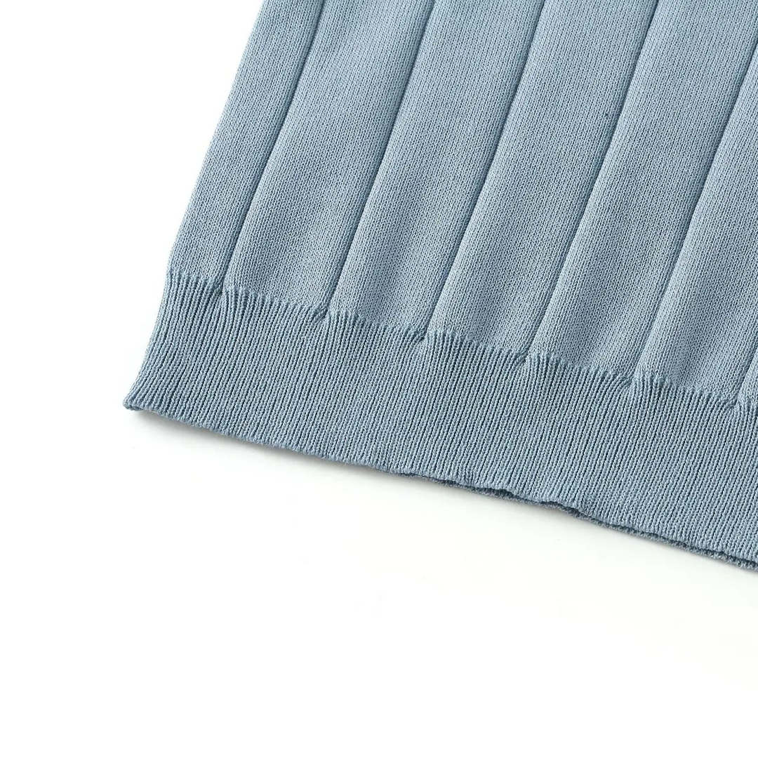 Blue polo shirt hem with ribbed trim beneath the vertical knit pattern