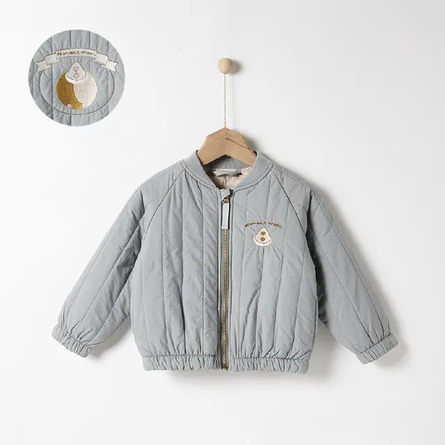 Blue quilted zip-front coat with gathered cuffs and hem, shown with a close-up of the chest embroidery