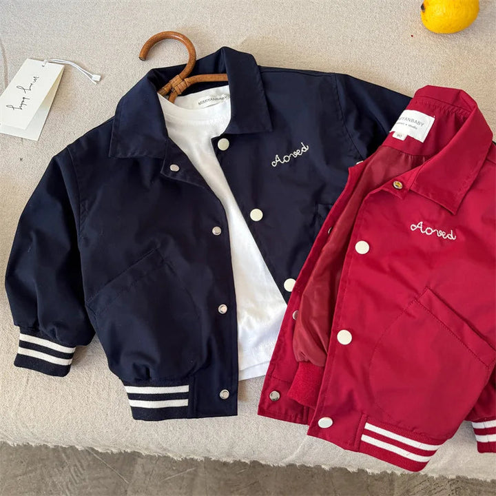 Blue and red baseball jackets arranged together to show their snap fronts and embroidered chest details