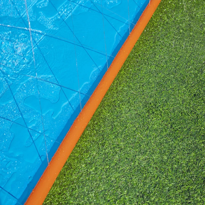 Close-up of the wet blue sliding surface and orange border on grass