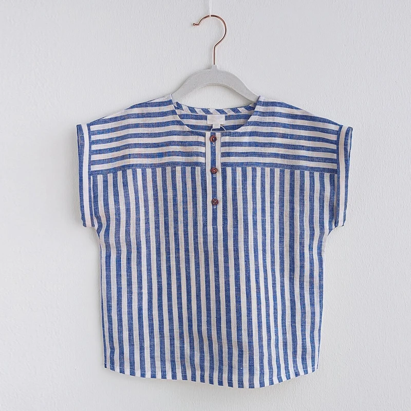 Blue striped cotton-linen shirt hanging against a light wall