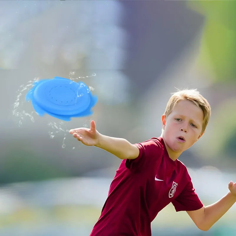 Boy throwing a blue water flying disc with splashes trailing around it