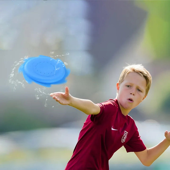 Boy throwing a blue water flying disc with splashes trailing around it