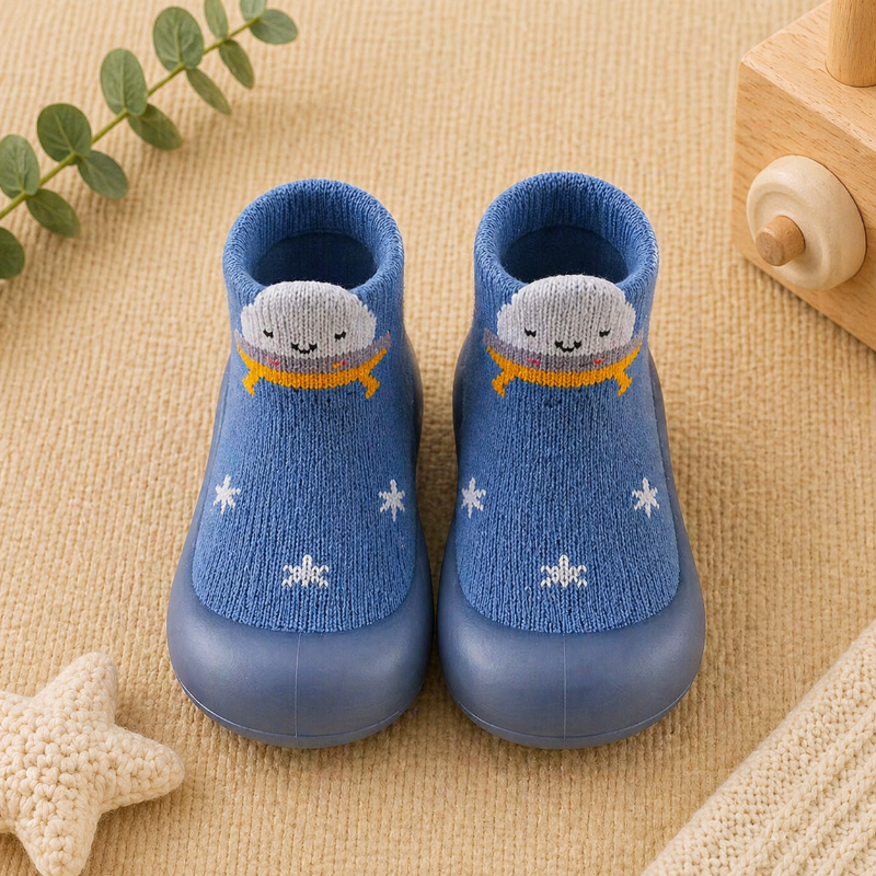 Blue knitted sock shoes with whale details and small white motifs.