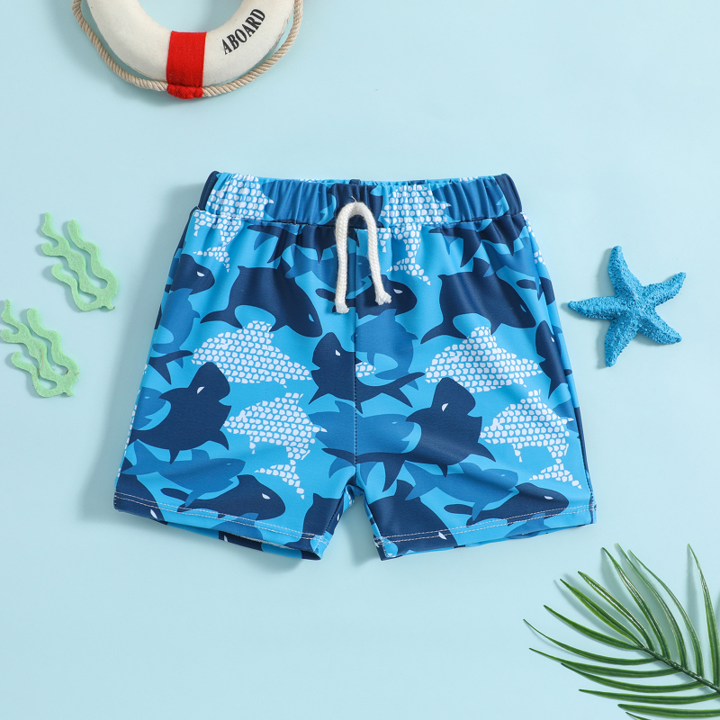 Blue whale shark-print swim trunks with a white drawstring, displayed flat on a light blue background
