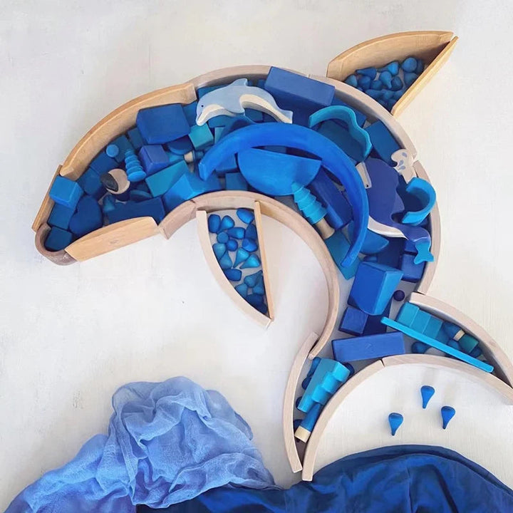 Blue wooden blocks arranged inside a dolphin-shaped wooden outline