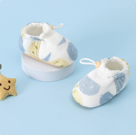 Blue and yellow printed baby shoes with white ankle openings and heel loops