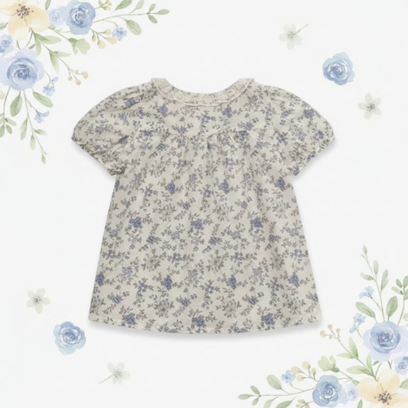 Back view of the botanical-print blouse with short puff sleeves and a flared shape
