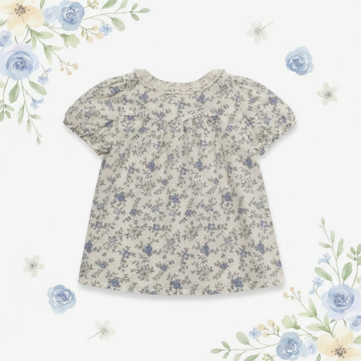 Back view of the botanical-print blouse with short puff sleeves and a flared shape