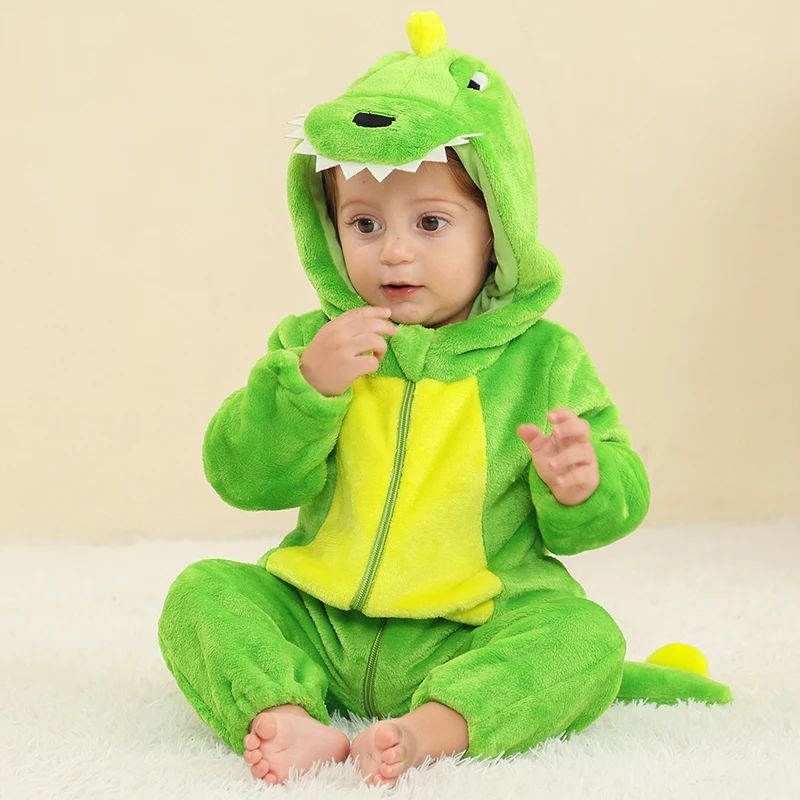 Baby seated in a bright green dragon onesie with a yellow belly and tooth-detail hood