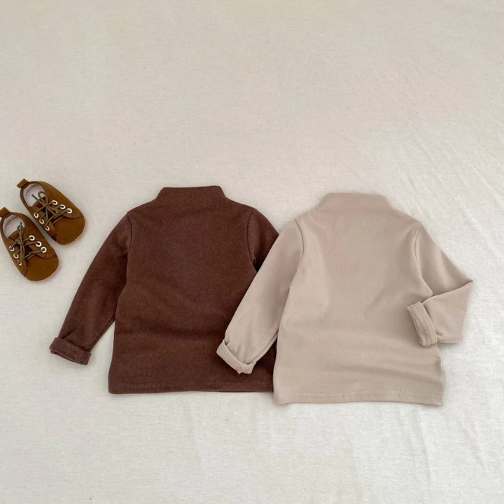 Brown and neutral beige long-sleeve baby sweaters laid flat side by side.