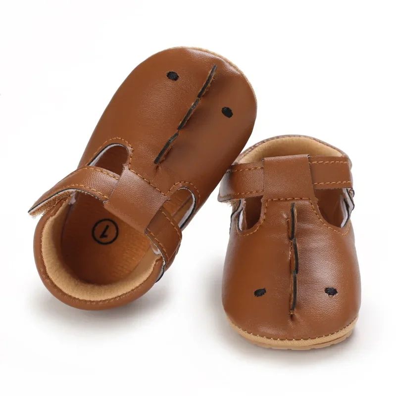 Brown animal-face baby shoes with a raised center seam and strap closures