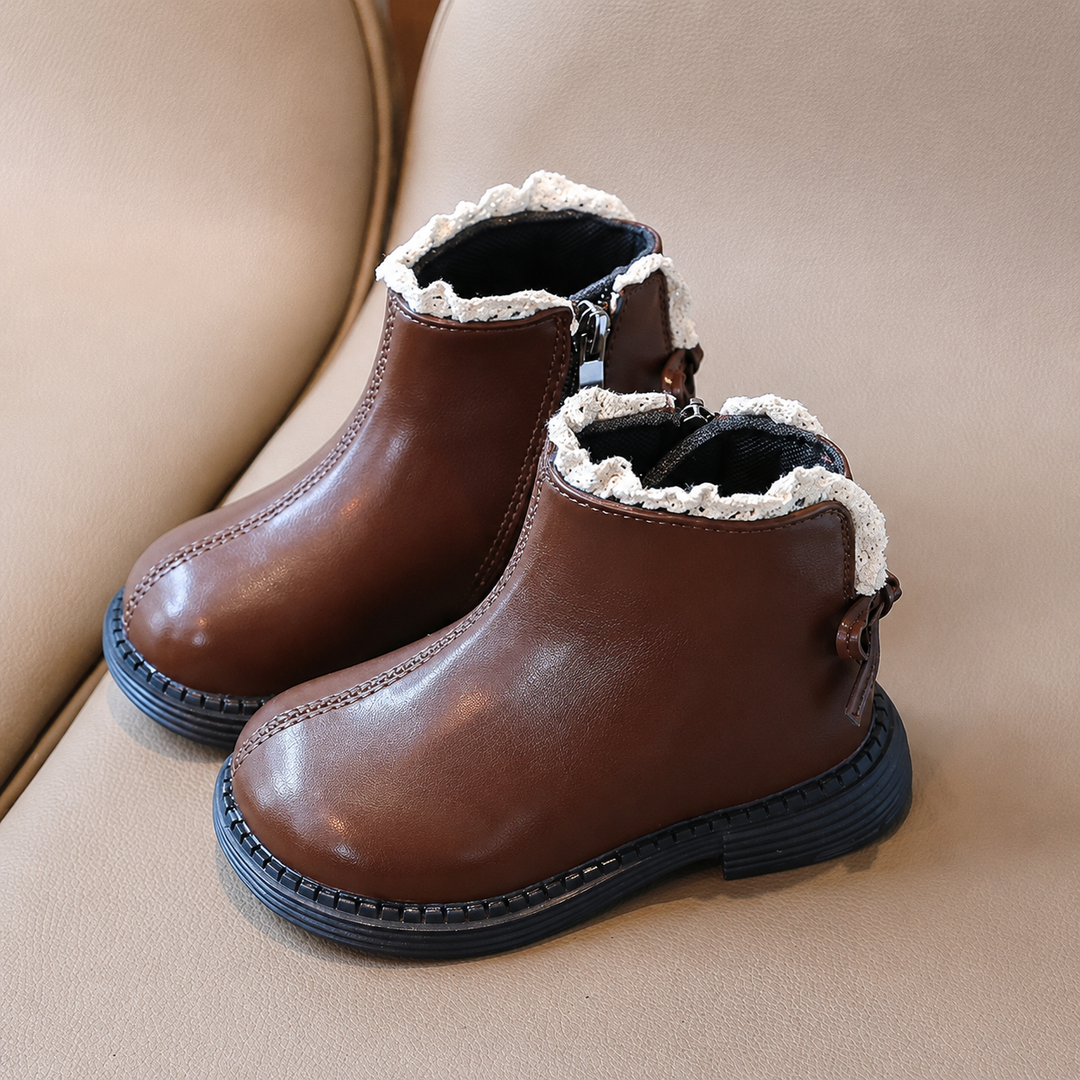 Pair of brown ankle boots with black soles and decorative cream ankle trim