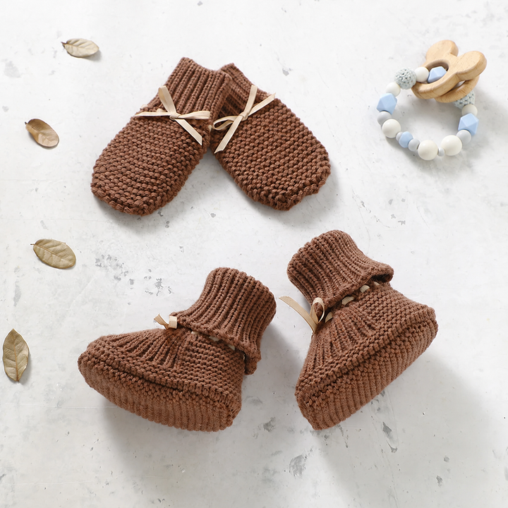 Brown knitted baby booties and matching mittens with ribbon ties