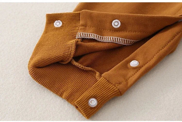 Snap fasteners and ribbed leg cuff on the brown baby jumpsuit