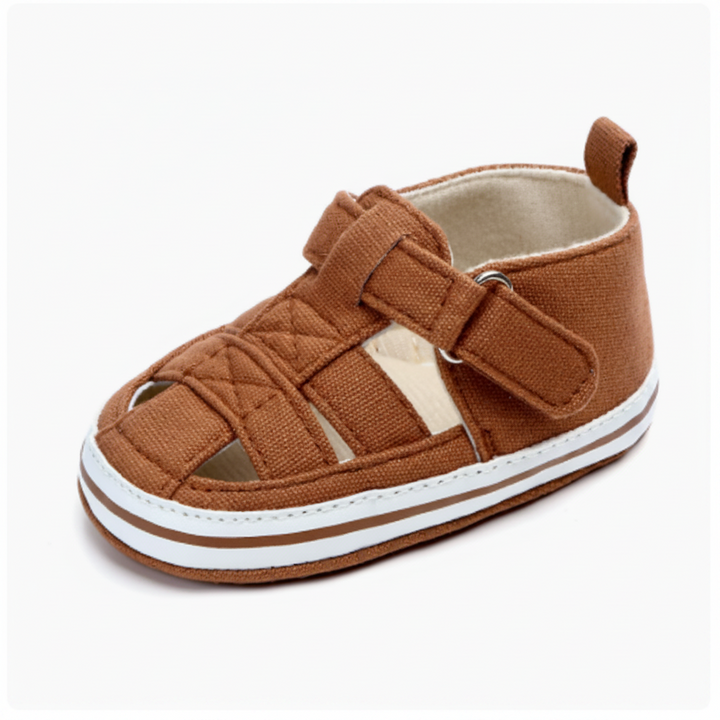 Brown baby sandal with quilted front detail, an ankle strap and white sole