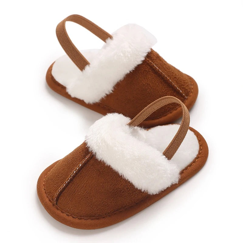 Brown baby slippers with white plush lining and elastic heel straps