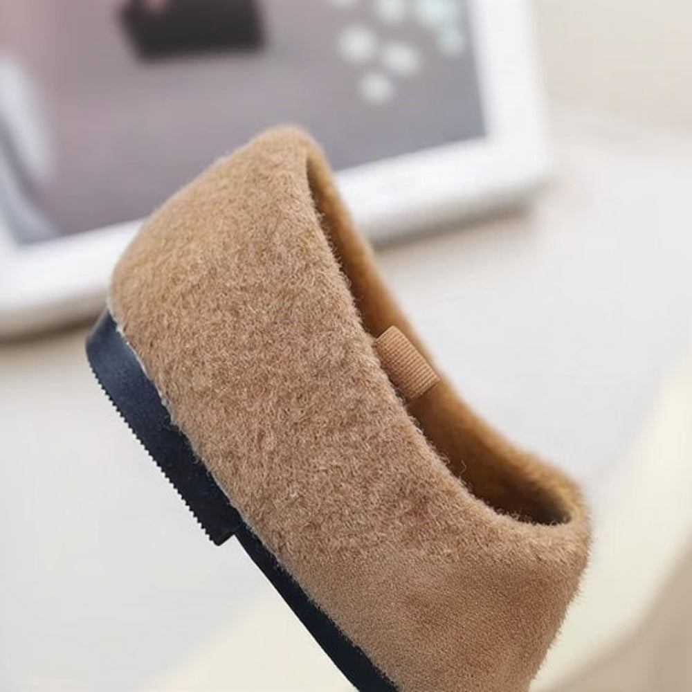 Rear view of a brown ballet flat showing its rounded heel and black outsole