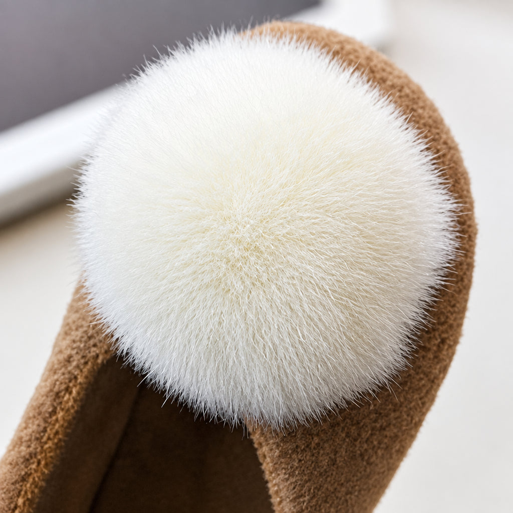 Close-up of the fluffy cream-colored pom-pom on a brown girls&